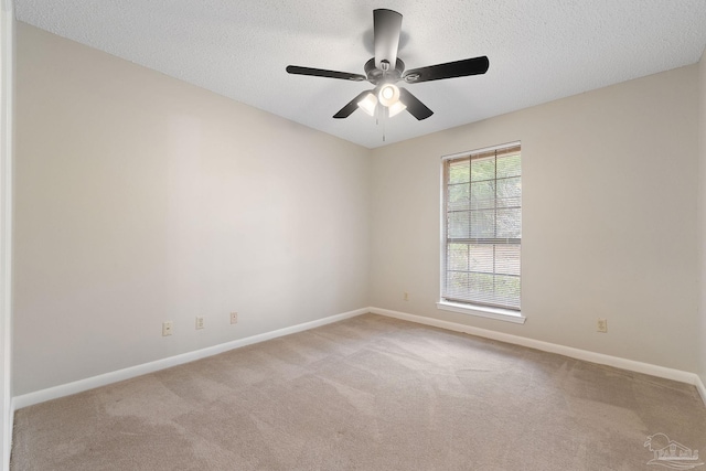 carpeted spare room with a textured ceiling and ceiling fan