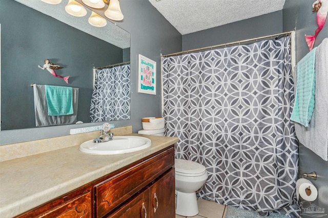 bathroom featuring tile patterned floors, vanity, toilet, and a textured ceiling