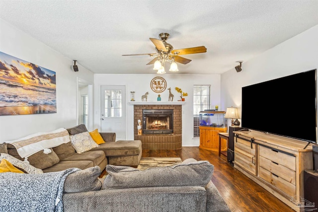 living room featuring a textured ceiling, dark wood-type flooring, and a wealth of natural light