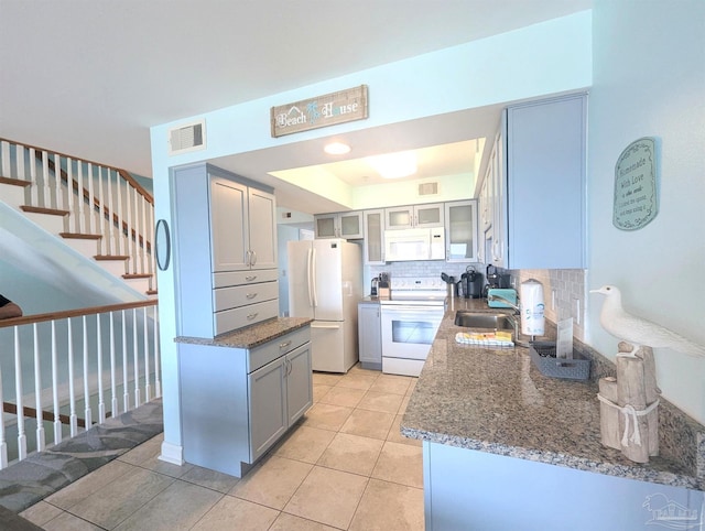 14391 Perdido Key Dr Unit D, Pensacola, FL 32507 - kitchen with white appliances, a sink, tasteful backsplash, gray cabinetry, and stone counters