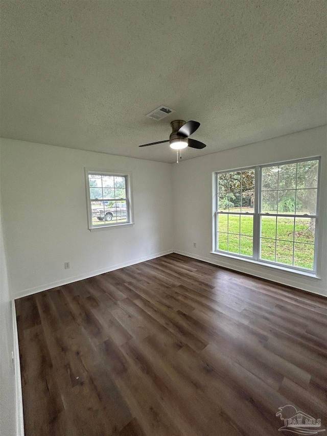 spare room featuring ceiling fan, dark hardwood / wood-style flooring, and a textured ceiling