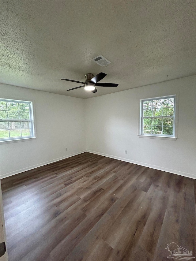 spare room with dark wood-type flooring, a textured ceiling, and ceiling fan