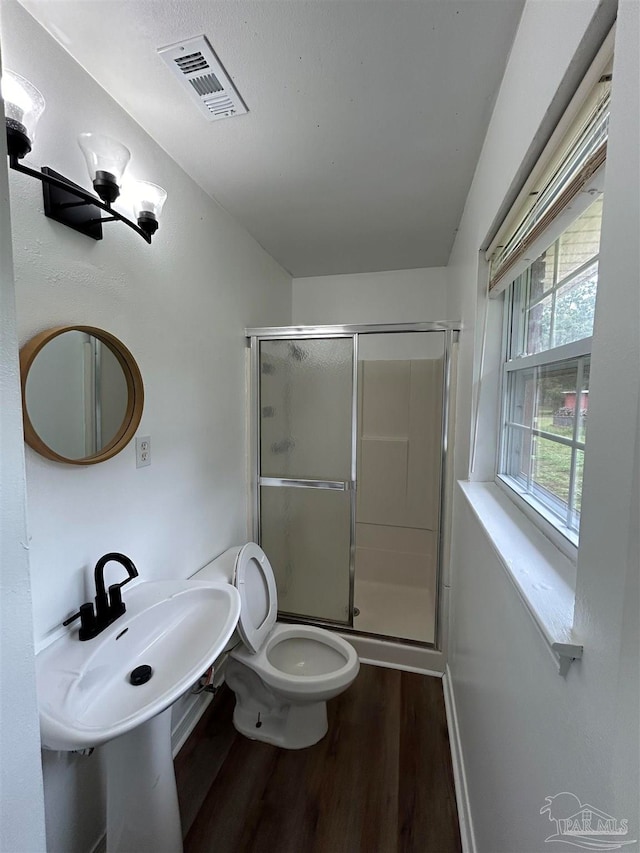 bathroom with toilet, hardwood / wood-style floors, and an enclosed shower