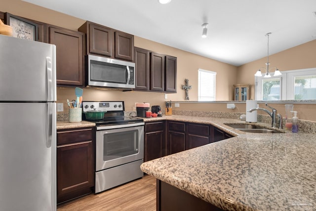 kitchen with a sink, stainless steel appliances, a healthy amount of sunlight, and dark brown cabinets