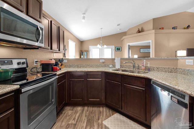 kitchen featuring light wood-style flooring, a sink, stainless steel appliances, dark brown cabinetry, and vaulted ceiling