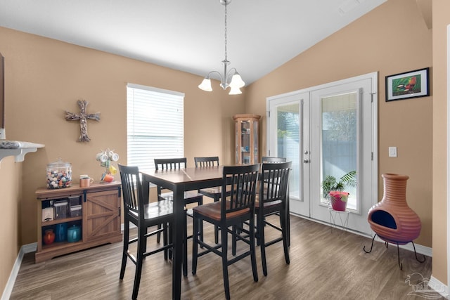 dining room with plenty of natural light, french doors, wood finished floors, and vaulted ceiling