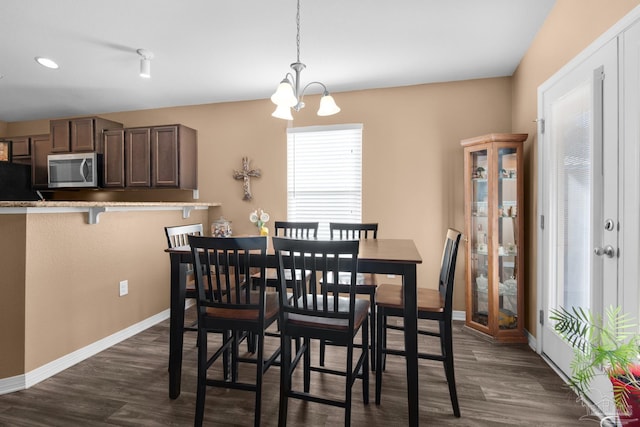 dining room featuring baseboards, an inviting chandelier, and dark wood-style floors