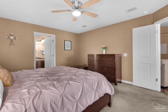 carpeted bedroom featuring ensuite bath, visible vents, baseboards, and a ceiling fan