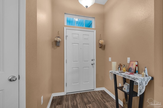 entryway with dark wood finished floors and baseboards