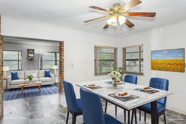 dining space with ceiling fan and crown molding