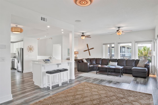 living room with ceiling fan and wood-type flooring