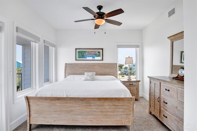 carpeted bedroom with ceiling fan and multiple windows