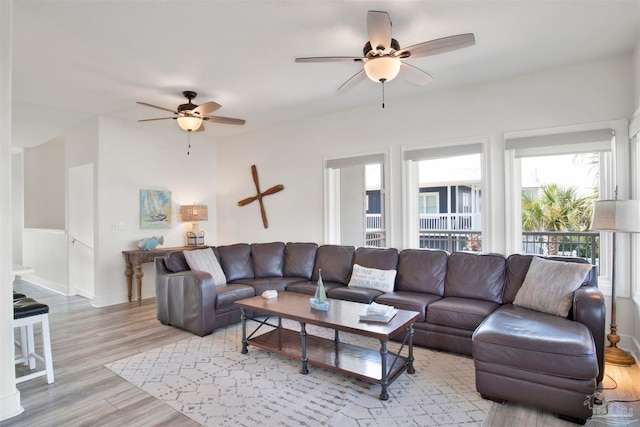 living room featuring ceiling fan and light hardwood / wood-style floors