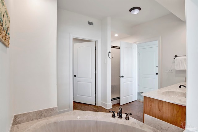 bathroom with tile patterned flooring, vanity, and a bathtub