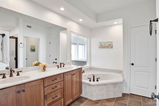 bathroom with tile patterned floors, tiled bath, and vanity