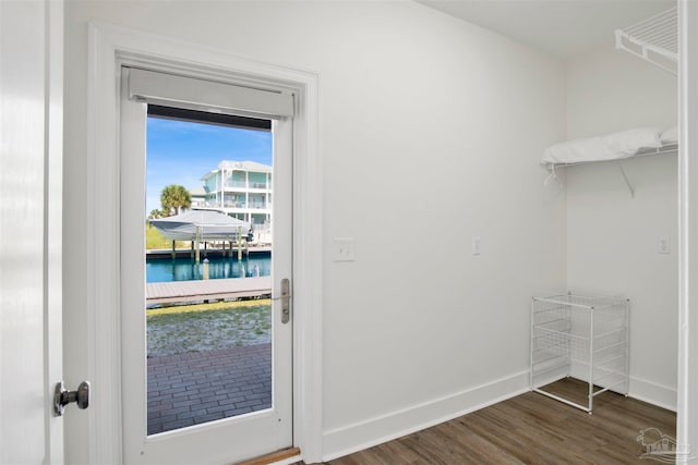 entryway with dark hardwood / wood-style floors and a water view