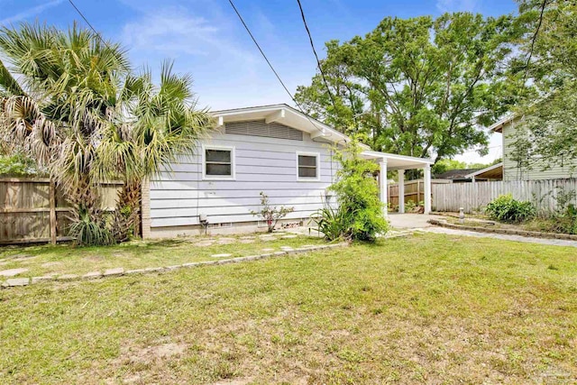1001 E Bobe St, Pensacola, FL 32503 - back of house featuring fence, a carport, concrete driveway, and a lawn