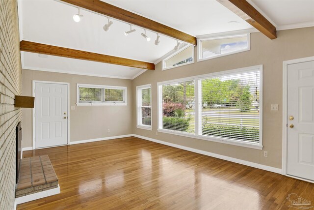 1001 E Bobe St, Pensacola, FL 32503 - unfurnished living room featuring baseboards, lofted ceiling with beams, wood finished floors, and a healthy amount of sunlight