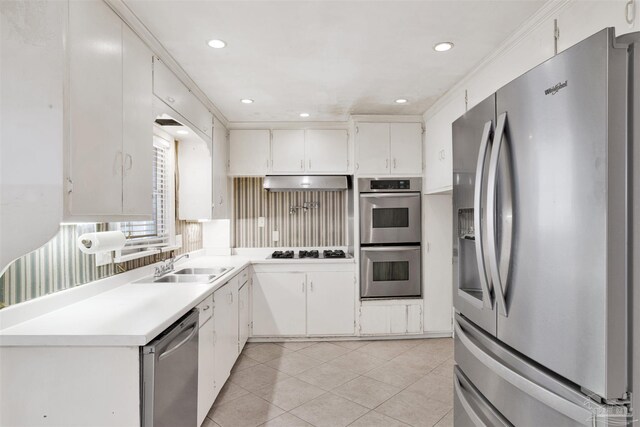 1001 E Bobe St, Pensacola, FL 32503 - kitchen with light countertops, under cabinet range hood, a sink, appliances with stainless steel finishes, and light tile patterned floors