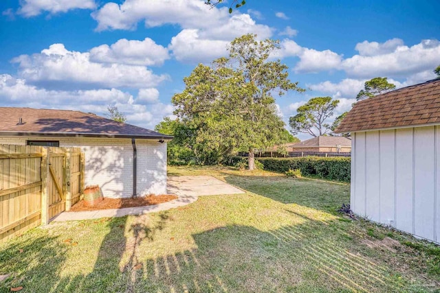 view of yard featuring an outdoor structure, a storage unit, and fence