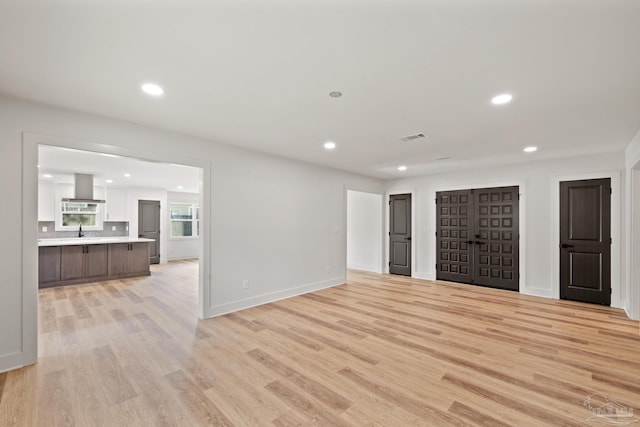 unfurnished living room featuring light wood finished floors, baseboards, visible vents, and recessed lighting
