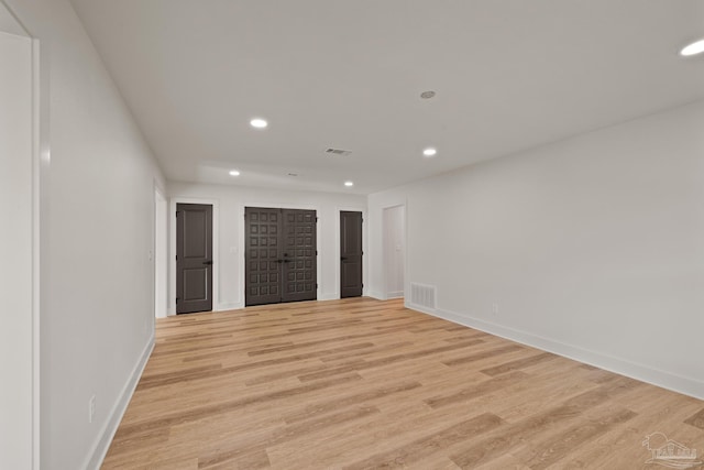 empty room featuring recessed lighting, light wood-style flooring, visible vents, and baseboards