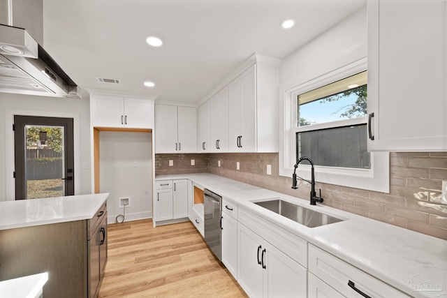 kitchen with light countertops, dishwasher, visible vents, and a sink