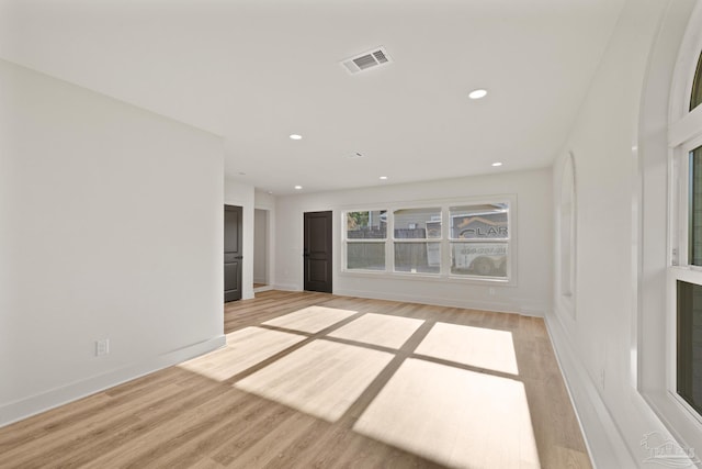 unfurnished living room with recessed lighting, light wood-style flooring, visible vents, and baseboards