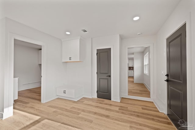 interior space featuring baseboards, visible vents, light wood-type flooring, and recessed lighting