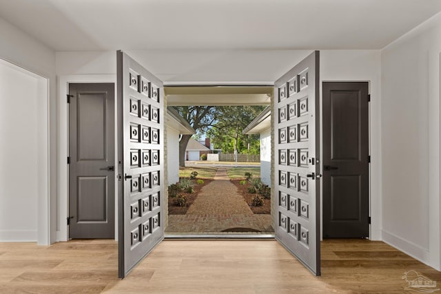 entryway with baseboards and wood finished floors