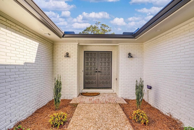 view of exterior entry featuring brick siding