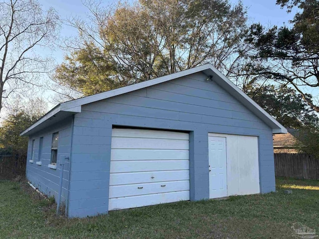 detached garage featuring fence