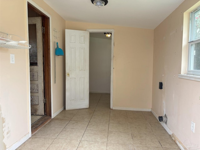 interior space with baseboards and light tile patterned floors