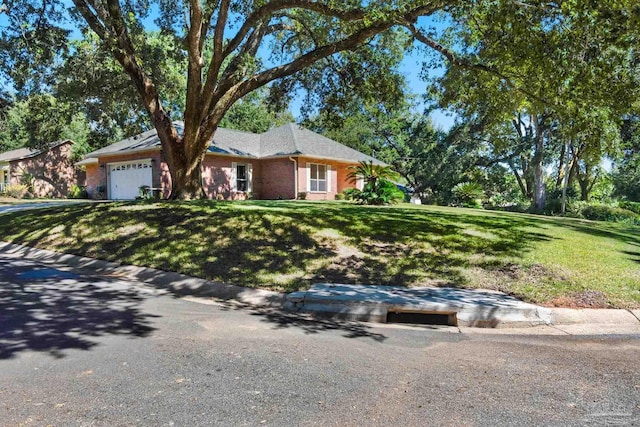 ranch-style home featuring brick siding, an attached garage, and a front yard