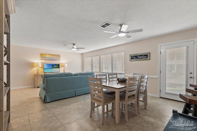 dining room featuring a ceiling fan, visible vents, baseboards, and light tile patterned floors