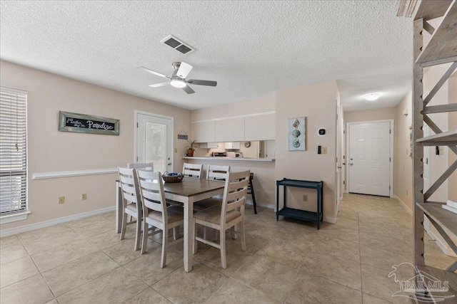 dining space featuring a healthy amount of sunlight, baseboards, visible vents, and a ceiling fan