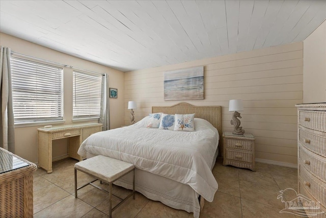 bedroom with light tile patterned floors, wood walls, wood ceiling, and baseboards