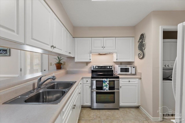 kitchen with white microwave, double oven range, white cabinetry, and a sink