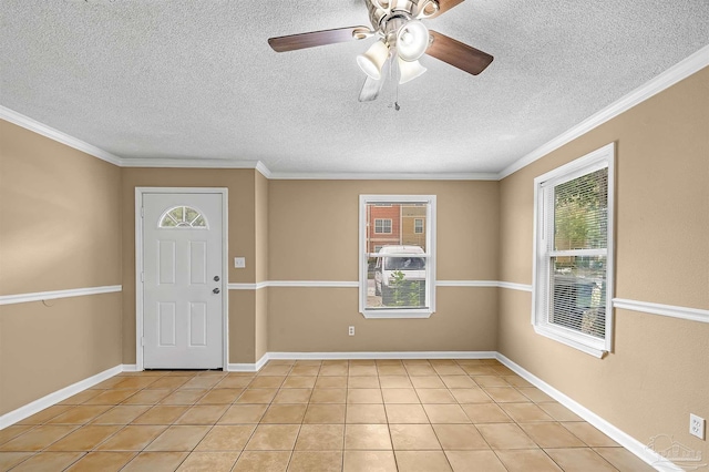 tiled foyer entrance featuring a textured ceiling and ornamental molding