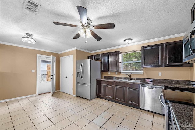 kitchen with appliances with stainless steel finishes, a textured ceiling, ornamental molding, and sink