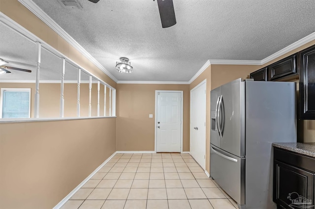 kitchen featuring a textured ceiling, stainless steel refrigerator with ice dispenser, light tile patterned floors, ornamental molding, and ceiling fan