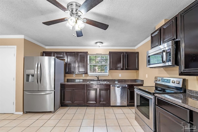 kitchen featuring appliances with stainless steel finishes, light tile patterned floors, a textured ceiling, ornamental molding, and sink