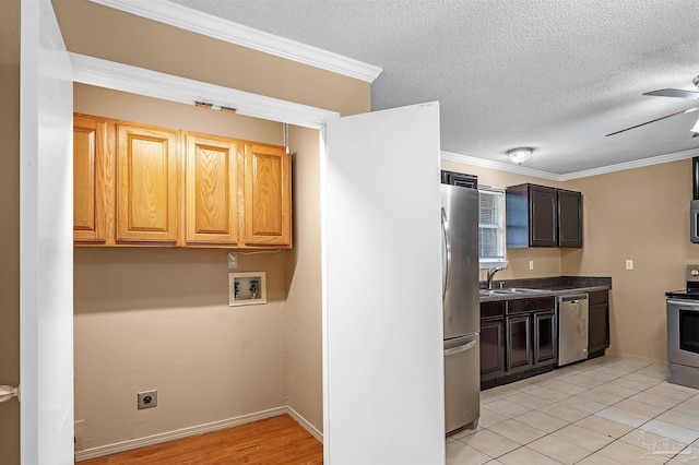 kitchen featuring sink, stainless steel appliances, light tile patterned floors, ornamental molding, and ceiling fan