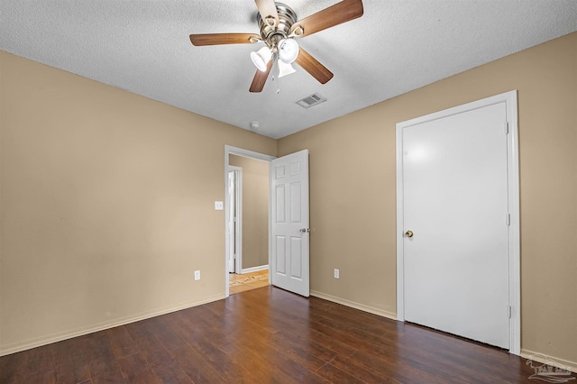 unfurnished bedroom with a textured ceiling, ceiling fan, and dark hardwood / wood-style flooring