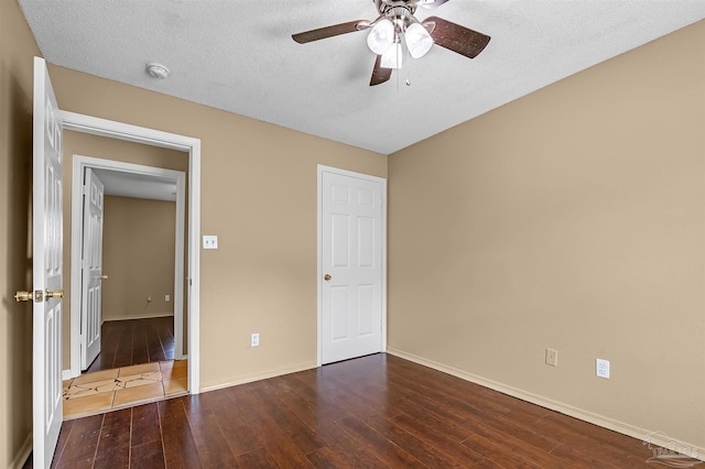 unfurnished bedroom featuring a textured ceiling, dark hardwood / wood-style flooring, and ceiling fan