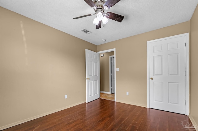 unfurnished bedroom featuring ceiling fan, dark hardwood / wood-style floors, and a textured ceiling