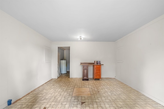 unfurnished room featuring water heater and ornamental molding