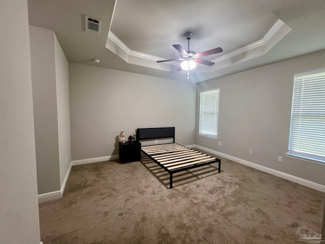 bedroom with carpet floors, a raised ceiling, crown molding, and ceiling fan