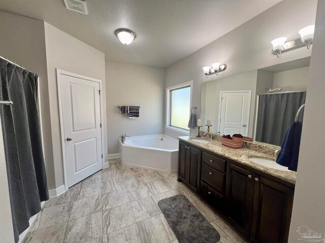 bathroom featuring vanity, shower with separate bathtub, and a textured ceiling