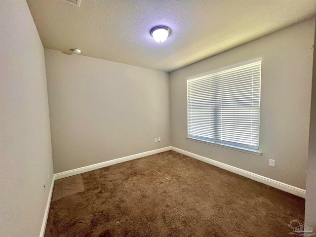 carpeted spare room featuring a textured ceiling